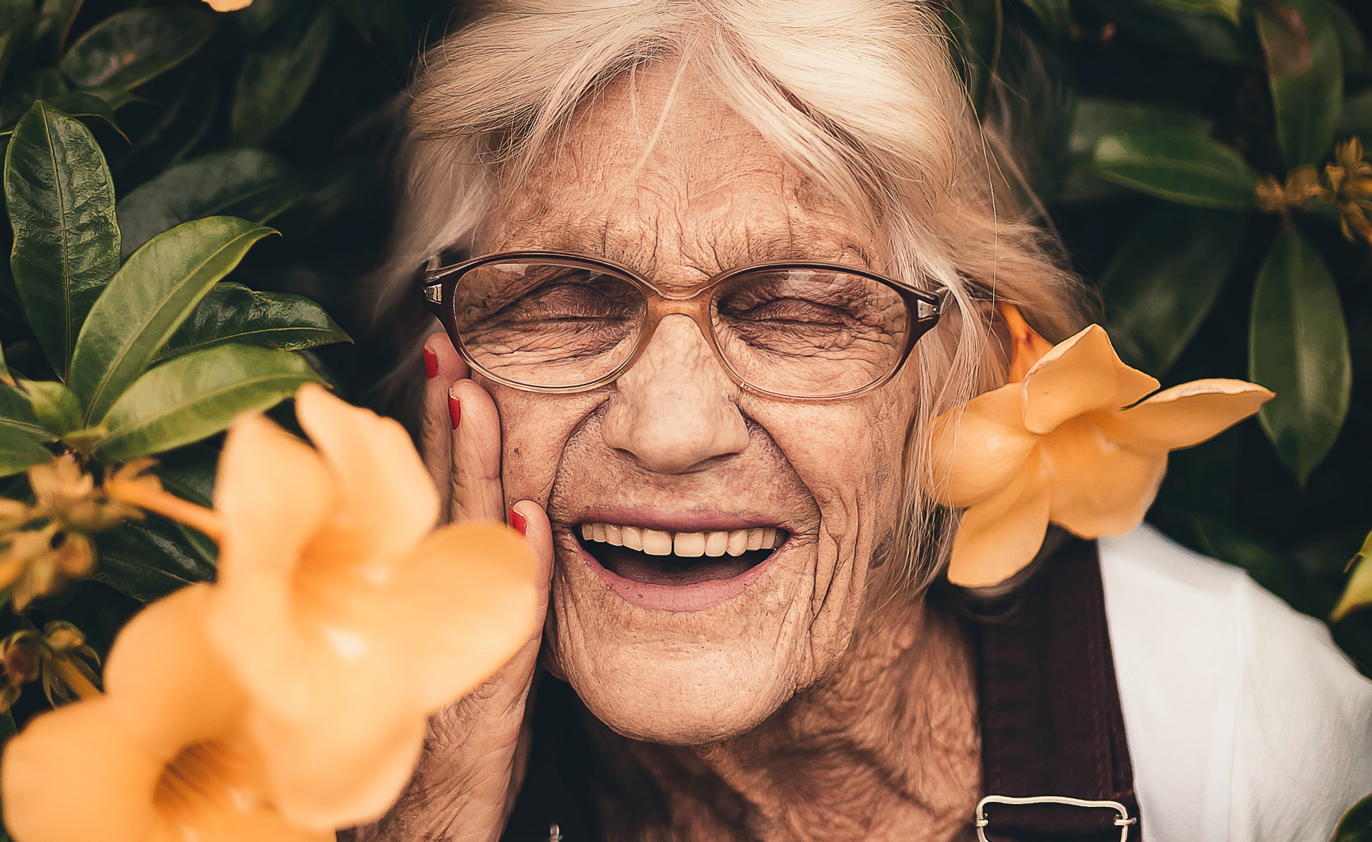 Elderly lady surrounded by greenery and orange flowers
